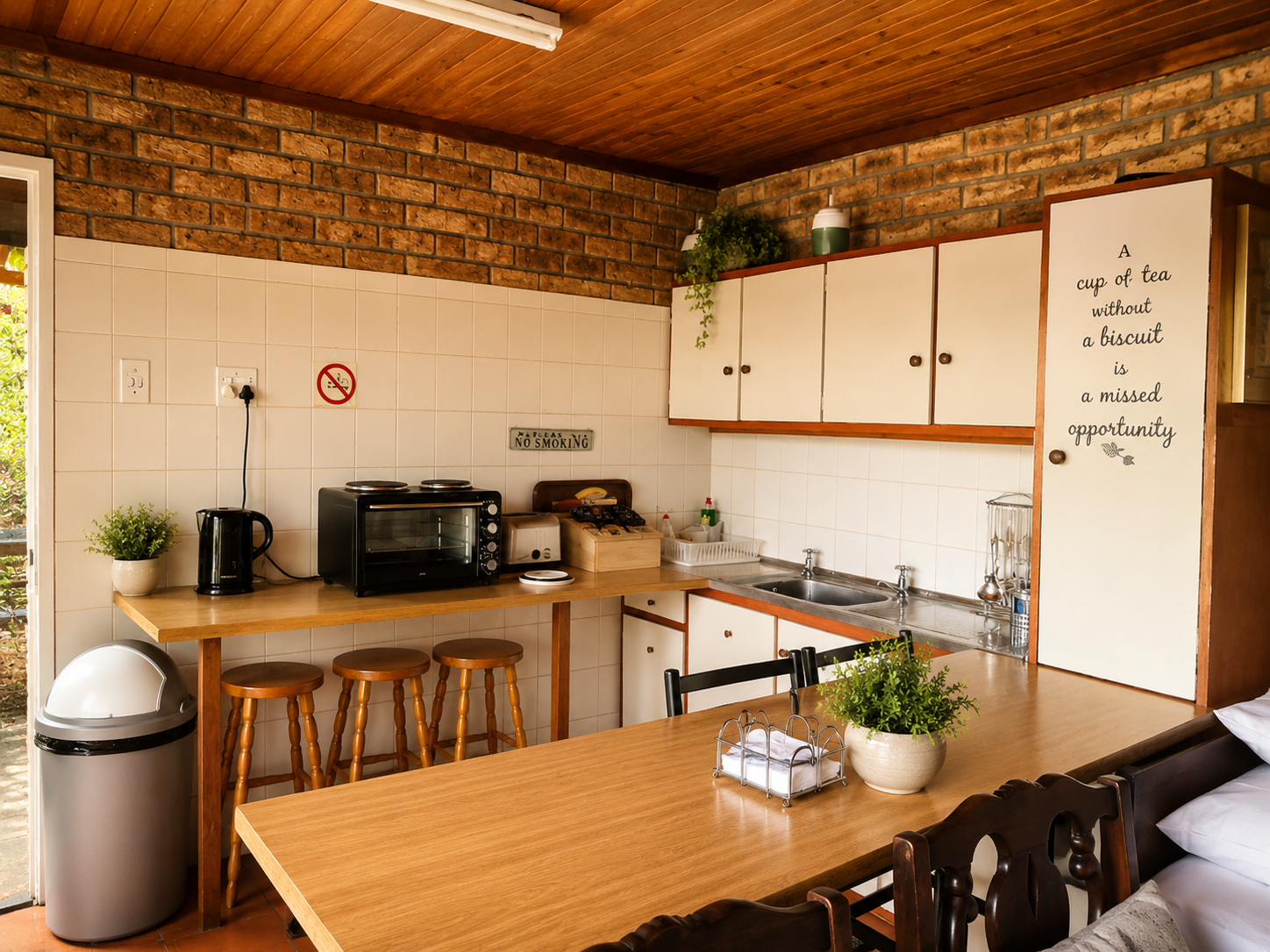 Self-catering kitchenette in the Protea Suite with dining table, kettle, toaster, oven and storage